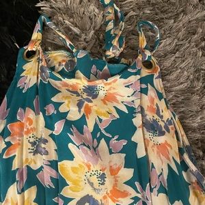 Floral print, ties in the back, easily adjustable, longer in the back.